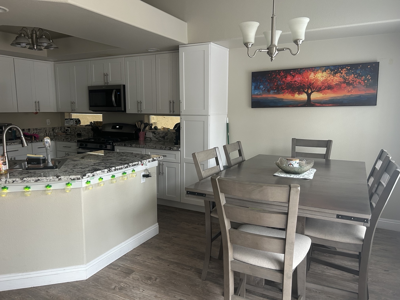 Kayla’s kitchen and dining area with a colorful tree painting